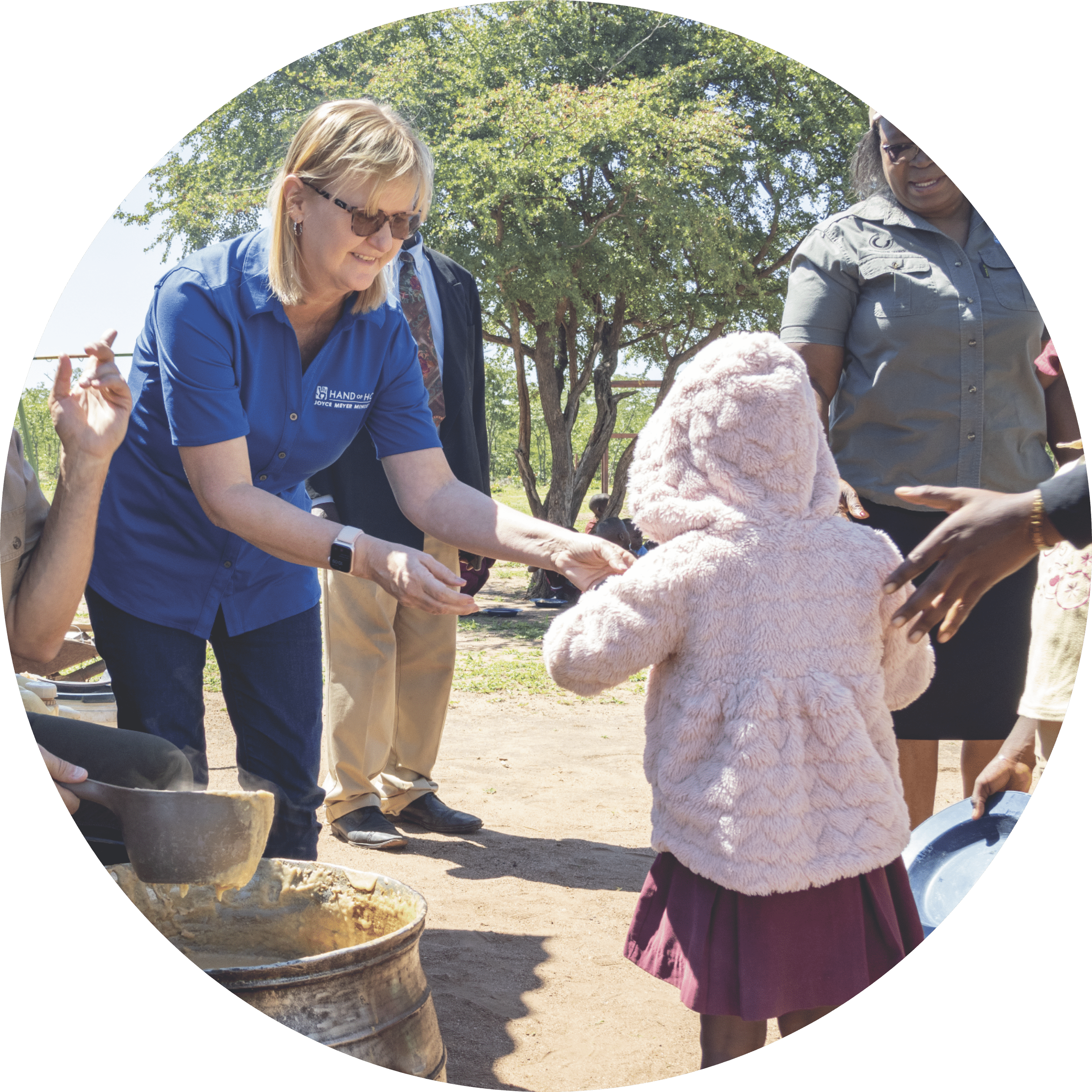 Image of a volunteer serving a young child food