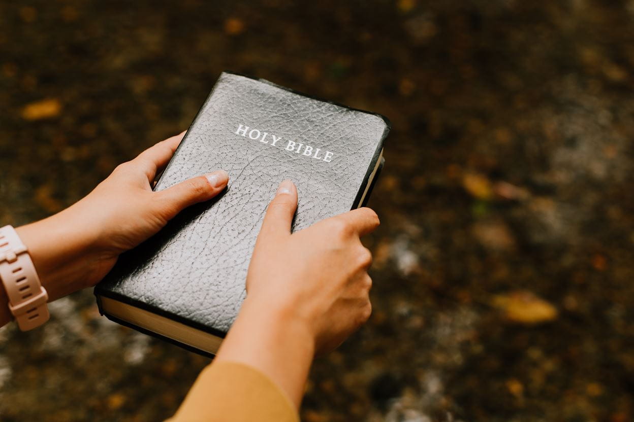 A woman's hands holding a Bible preparing to read and seek God's wisdom