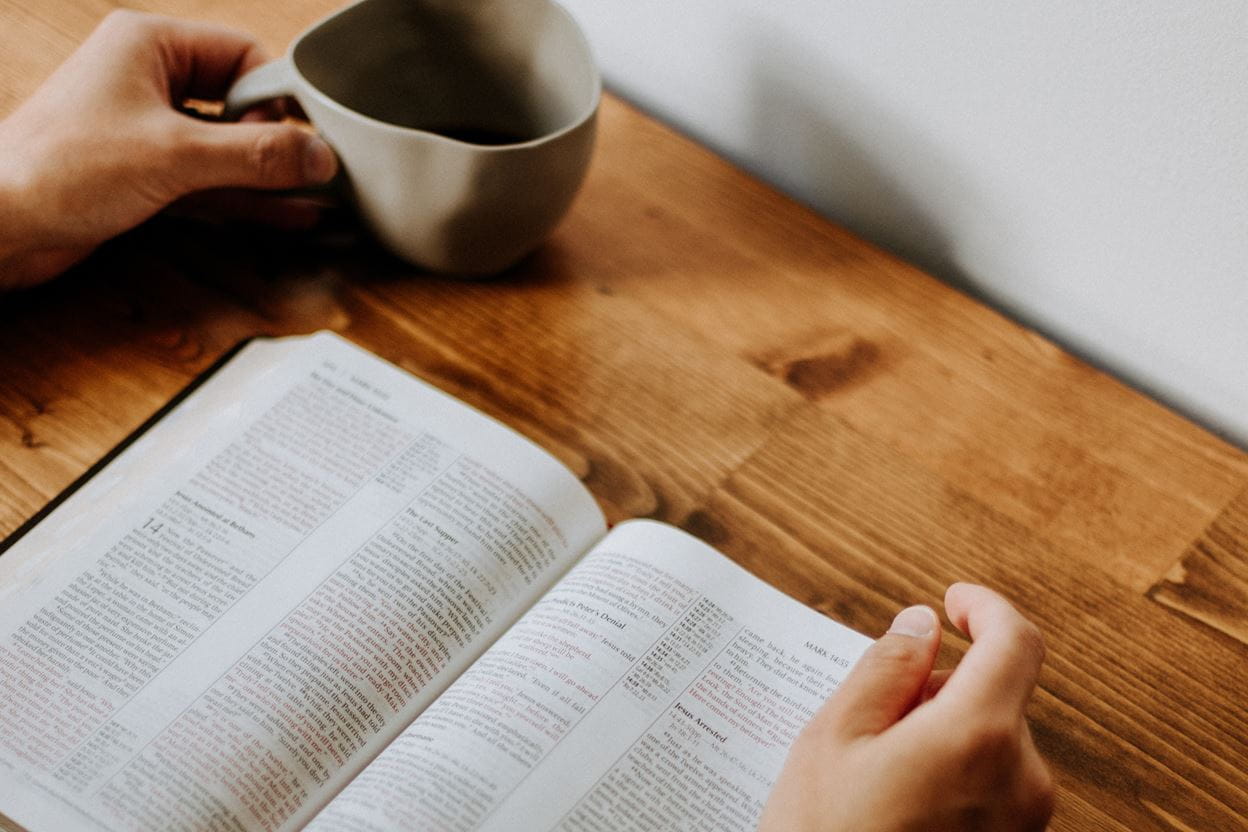 An open Bible on a desk being read for a daily devotional.